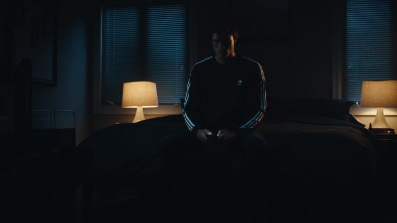 A person sitting on a bed in a dark room