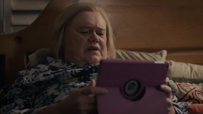 Louie Anderson sitting on a bed