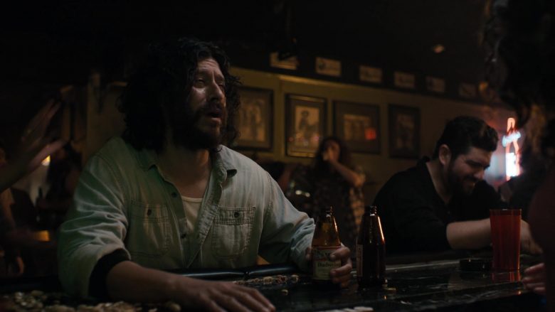 A man sitting at a table with beer bottle