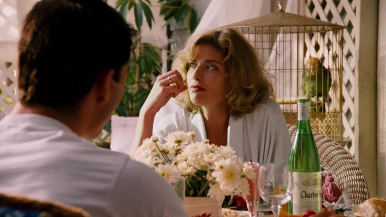 Kelly McGillis sitting at a table with a vase of flowers