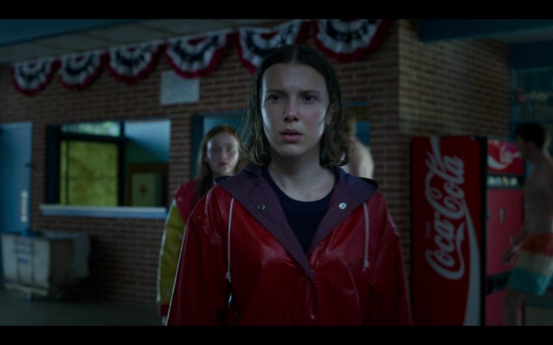 Millie Bobby Brown in a red rain coat