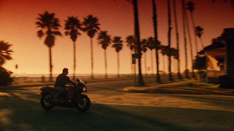 A person riding a motorcycle with a sunset in the background