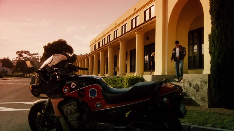 A person riding a motorcycle in front of a building