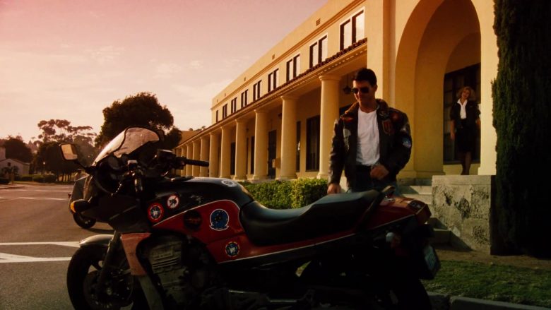 A man sitting on a motorcycle in front of a building