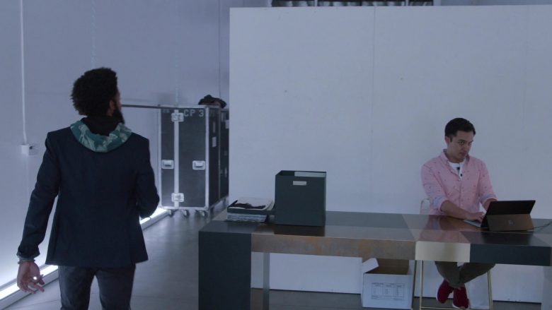 A man and a woman standing in front of a computer