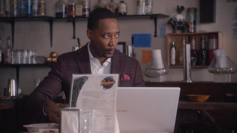 Yohance Myles sitting at a table with a laptop