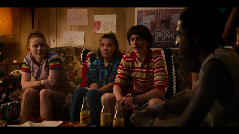 Millie Bobby Brown, Noah Schnapp sitting on a couch