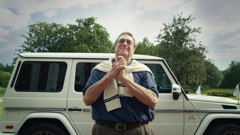 John Goodman standing in front of a car
