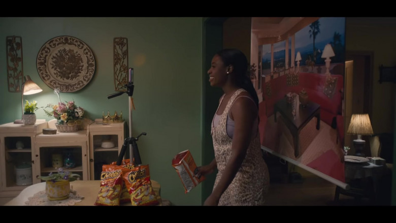 CHEETOS Crunchy FLAMIN’ HOT Cheese Flavored Snacks Held by Kirby Howell-Baptiste as JoJo Johnson in Queenpins Movie (2)