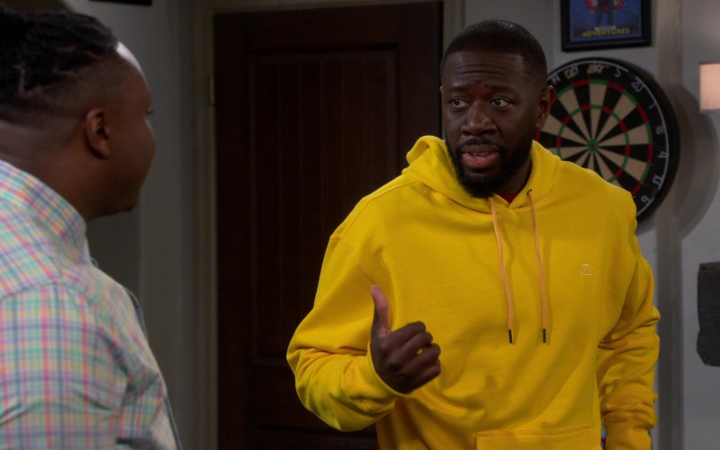 Champion Yellow Hoodie of Sheaun McKinney as Malcolm Butler in The Neighborhood S05E07 Welcome to the Working Week (2022)